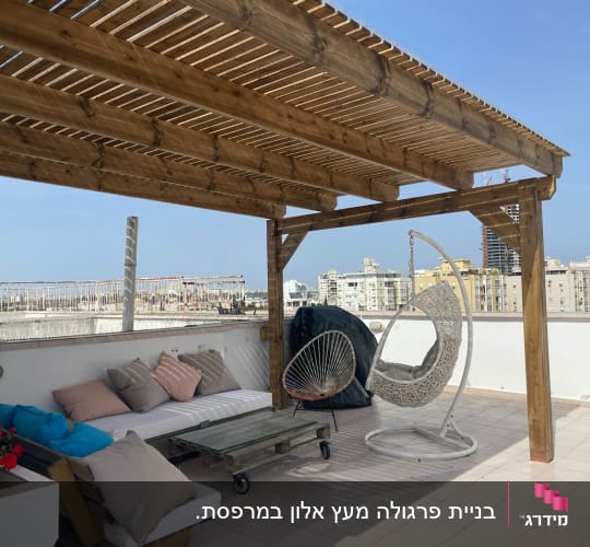פרגולה מעץ על גג עם כיסאות תלויים